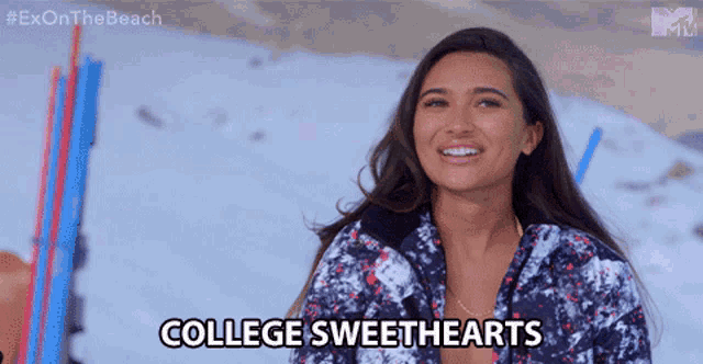a woman in a ski suit says college sweethearts on the beach