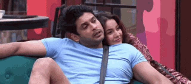 a man and woman are sitting on a green couch