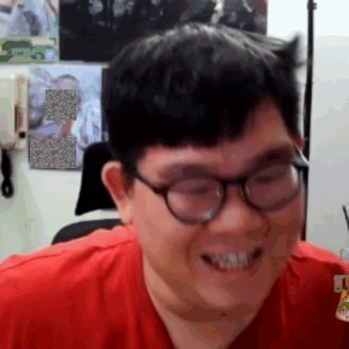 a man with glasses and a red shirt is smiling