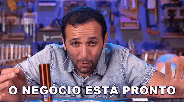 a man in a denim shirt is holding a copper tube with the words o negócio esta pronto below him