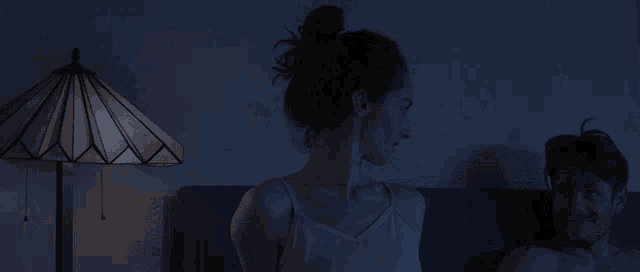 a person laying on a bed with their head down in the dark