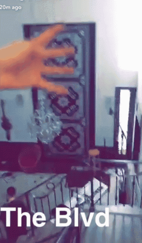 a person 's hand is reaching out towards a mirror with the words the blvd on the bottom