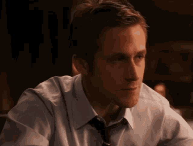 a man in a white shirt and tie is looking at something