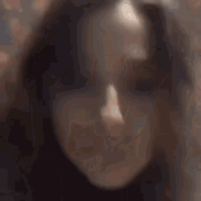 a close up of a person 's head with a blurred background of leaves .