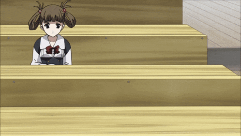 a girl in a school uniform sits at a wooden table