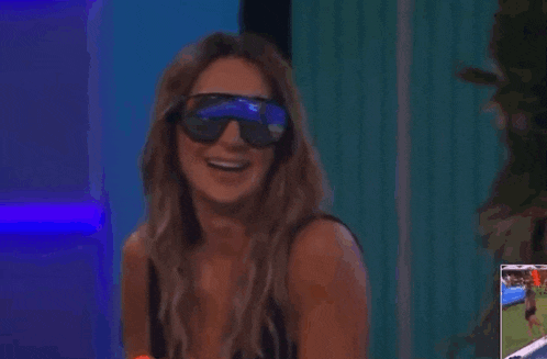 a woman is wearing sunglasses and holding a water gun .