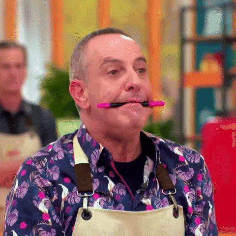 a man with a pink marker in his mouth is making a funny face .