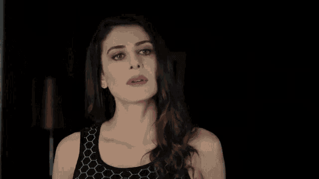 a woman wearing a black tank top with a honeycomb pattern on it