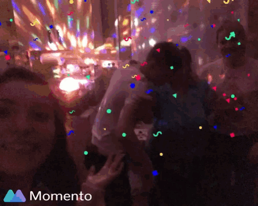 a group of people are dancing in a room with confetti falling from the ceiling and the words momento on the bottom right