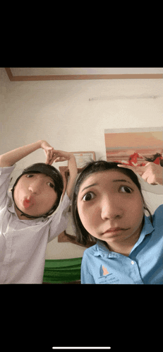 two girls are making funny faces and one is wearing a shirt that says sailboat on it