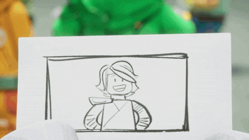 a person in a green jacket is holding a piece of paper with a drawing of a lego character on it .