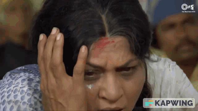 a woman with blood on her forehead is shown in a video that says kapwing on the bottom