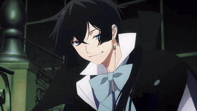 a man with black hair and blue eyes is wearing a bow tie and earrings
