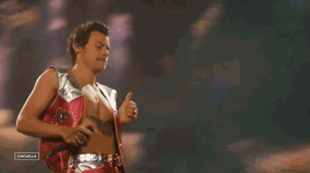 a man without a shirt is singing into a microphone on a stage ..