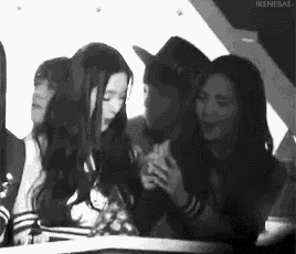 a group of young women are sitting next to each other in a room .