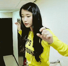 a girl wearing a yellow shirt that says ' s ' on it is standing in a hallway