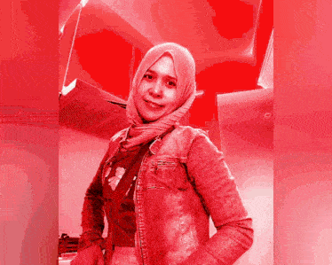 a woman wearing a hijab and a denim jacket has a red background