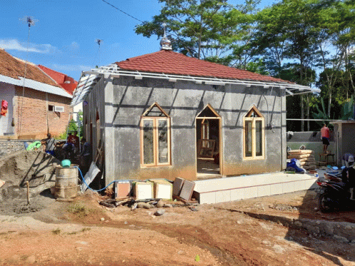 a small building with a red tile roof is under construction