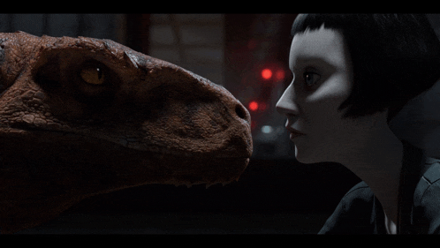 a woman looks at a dinosaur in a dark room