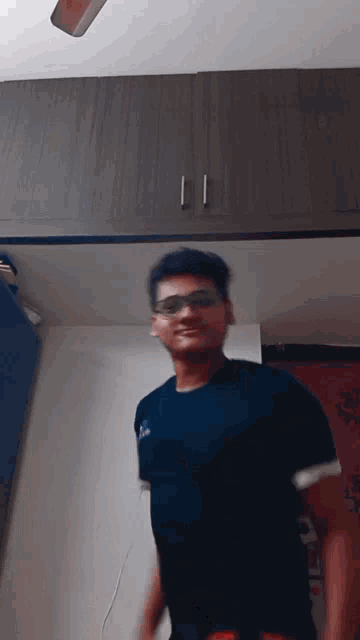 a young man wearing sunglasses and a blue shirt is dancing