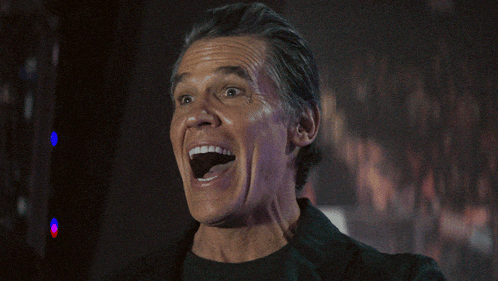 a man is laughing with his mouth open