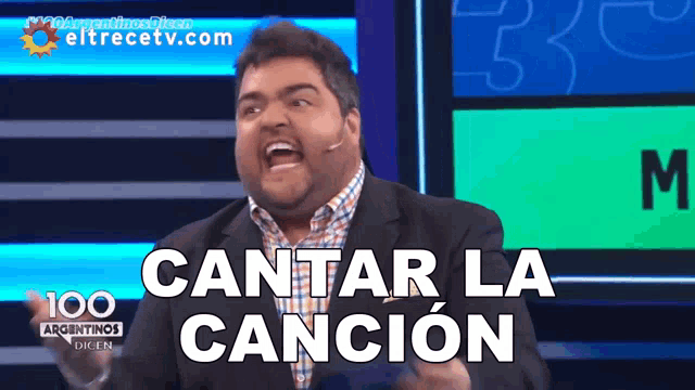 a man in a suit says cantar la cancion on a television screen