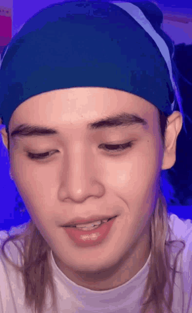 a close up of a man wearing a blue headband and smiling