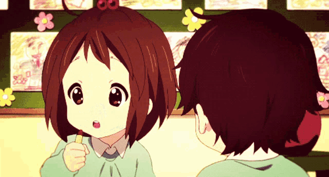a boy and a girl are looking at each other in a room with flowers on the wall