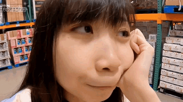 a woman making a funny face in a warehouse with chinese writing on the bottom right corner