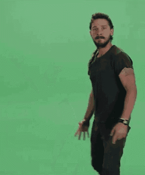a man in a black shirt is dancing with the words `` do it '' on a green screen .