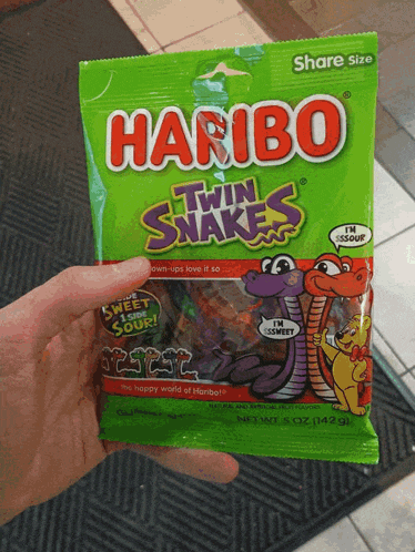 a person holds a bag of haribo twin snakes