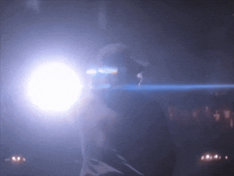 a person is standing in a dark room with a light behind them