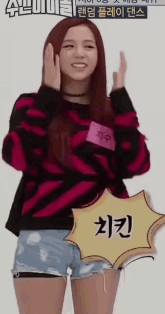 a girl with red hair is wearing a pink and black striped sweater and shorts