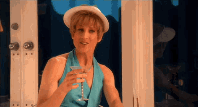 a woman in a blue dress holds a martini glass