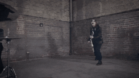 a man playing a guitar in an empty room