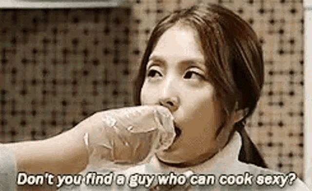 a woman is holding a plastic glove in her mouth and says `` don 't you find a guy who can cook sexy '' .