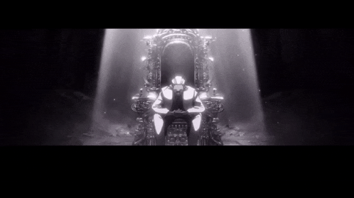 a man in a suit is sitting in a chair in a dark room