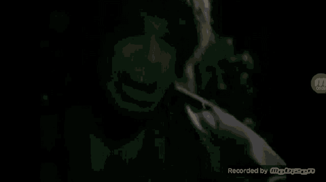 a close up of a person 's face with their mouth open in a dark room .