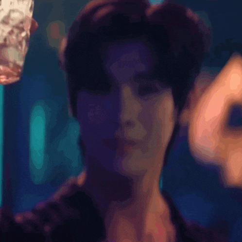 a blurry picture of a man holding a glass in his hand