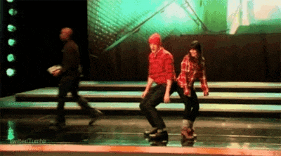 a man and a woman are dancing on a stage in front of a crowd .