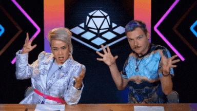 a man and a woman sitting at a table with their hands up