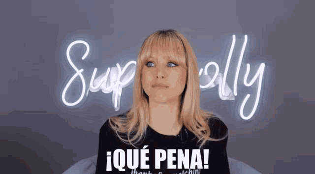 a woman is sitting in front of a neon sign that says superally