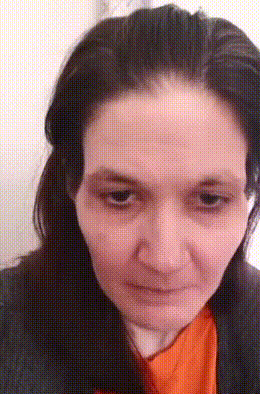 a woman with long black hair is wearing an orange shirt