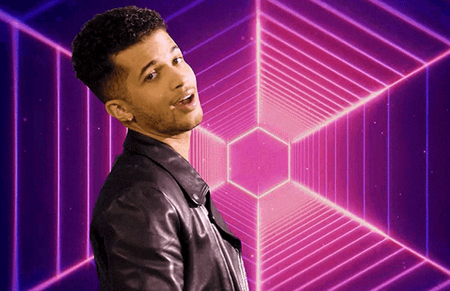 a man in a leather jacket is standing in front of a purple and blue background
