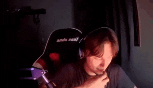 a man wearing headphones is sitting in a chair and smiling at the camera .