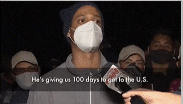 a man wearing a face mask is being interviewed by a reporter from fox news