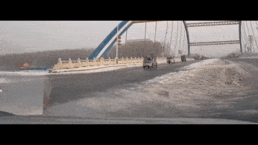 a car is driving across a bridge in the winter