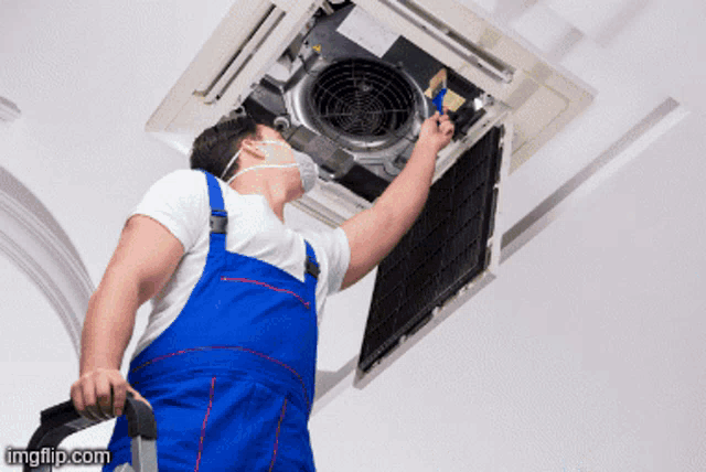 a man wearing a mask is working on a fan