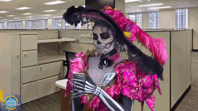 a woman dressed in a day of the dead costume looks at her phone
