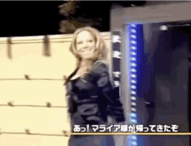 a woman is standing in front of a blue sign that says ' a ' on it